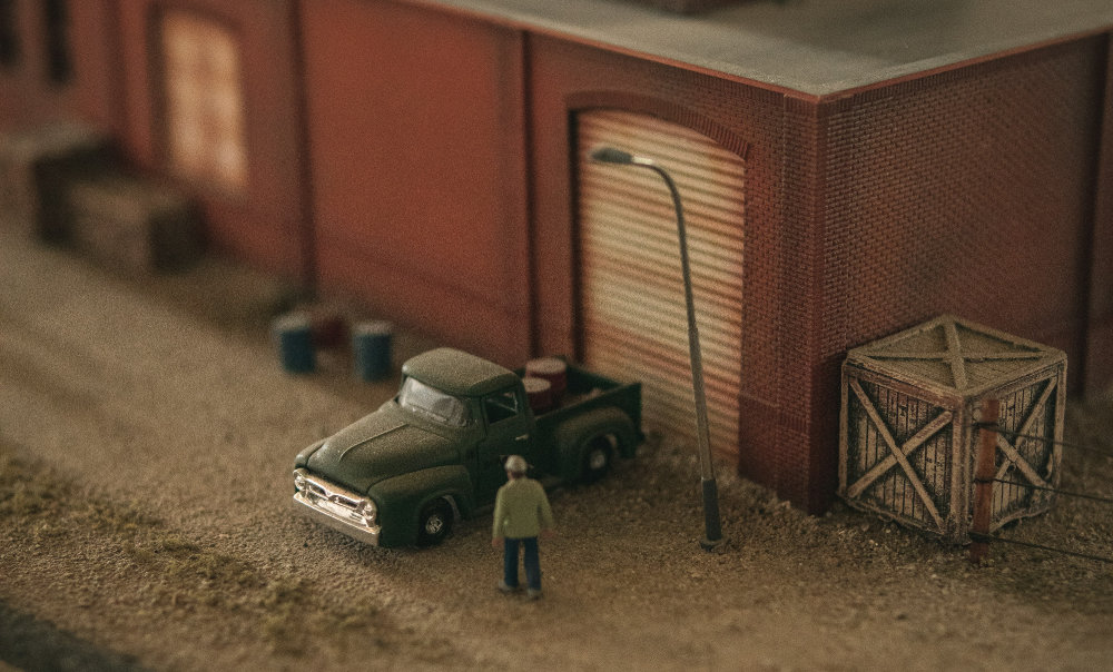 Close up of a diaramma showing a miniature man walking to his miniature truck.